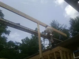 Carpenter setting a ridge beam over a new addition frame — Ice Dam Removal by Roofing Brothers in King Hill