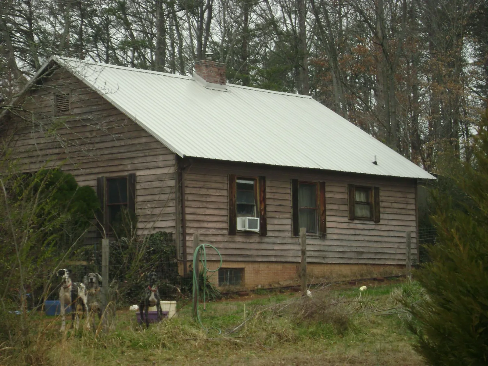 White metal roof on an old wood sided farmhouse, from a Metal Roof Installation job in King Hill