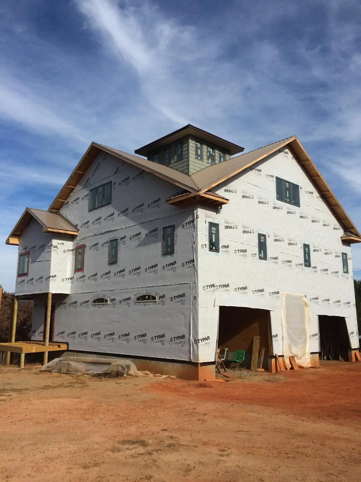 New two story house under construction with a cupola and gabled roofs in King Hill